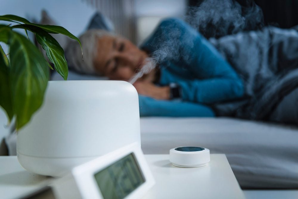 stock photo of a sleeping woman using a humidifier