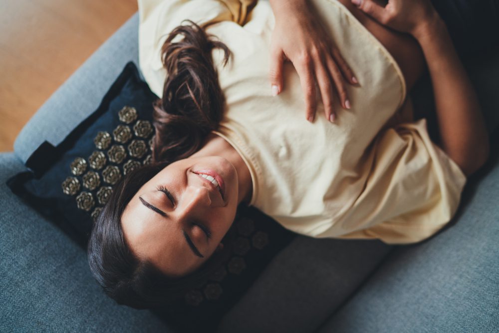 stock photo of a young woman laying on her back with a smile