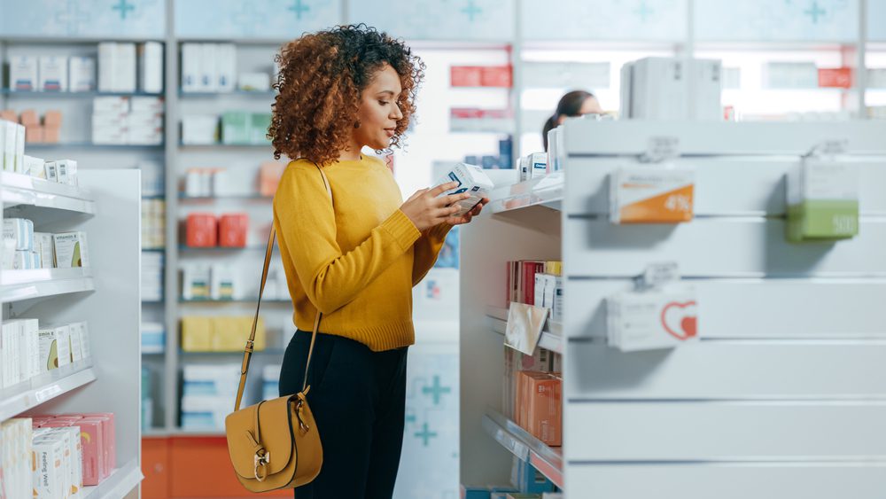 stock photo of a woman choosing medicine at a store