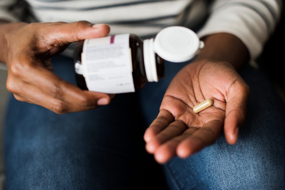 A person pours a pill into their hand