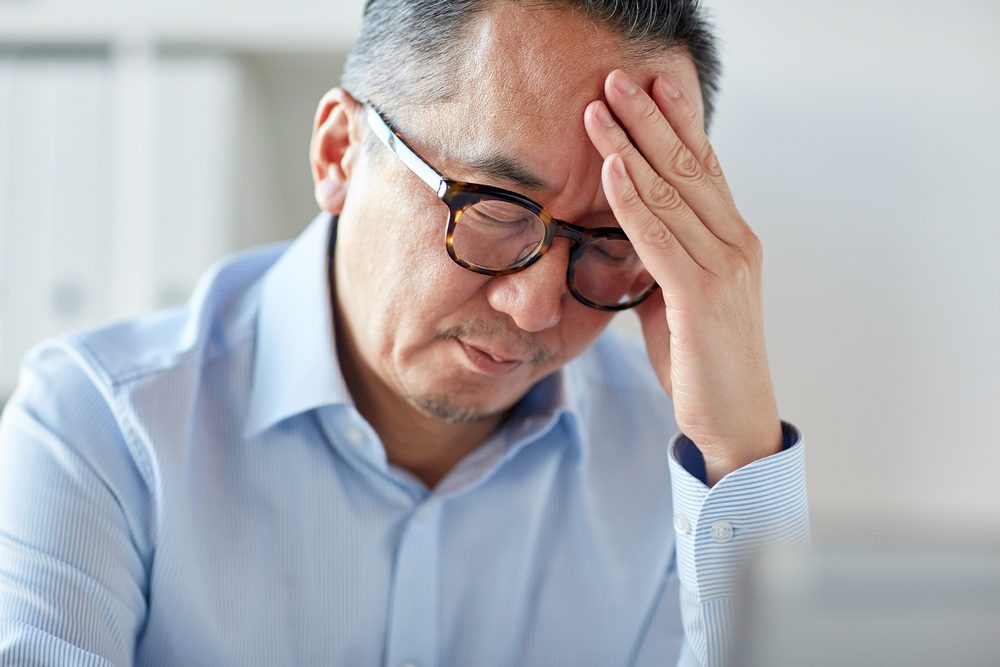 stock photo of an older man experiencing a headache