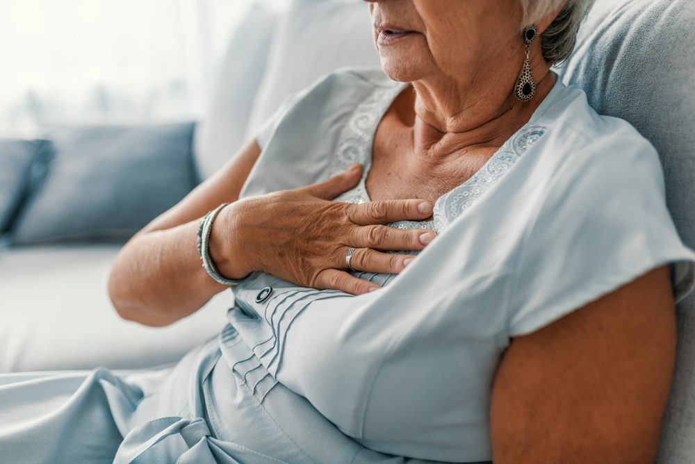 stock photo of an older woman holding her chest