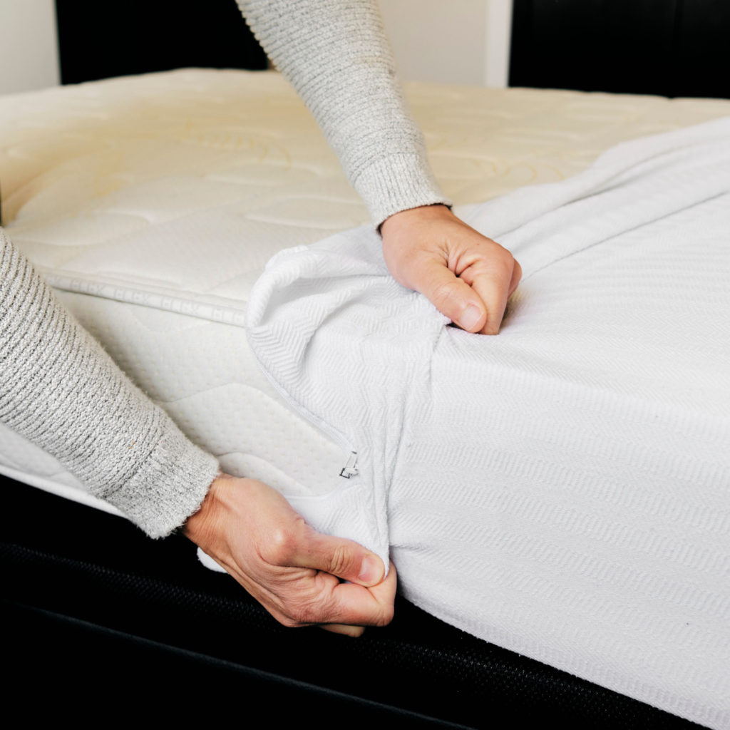 Man installs a mattress protector