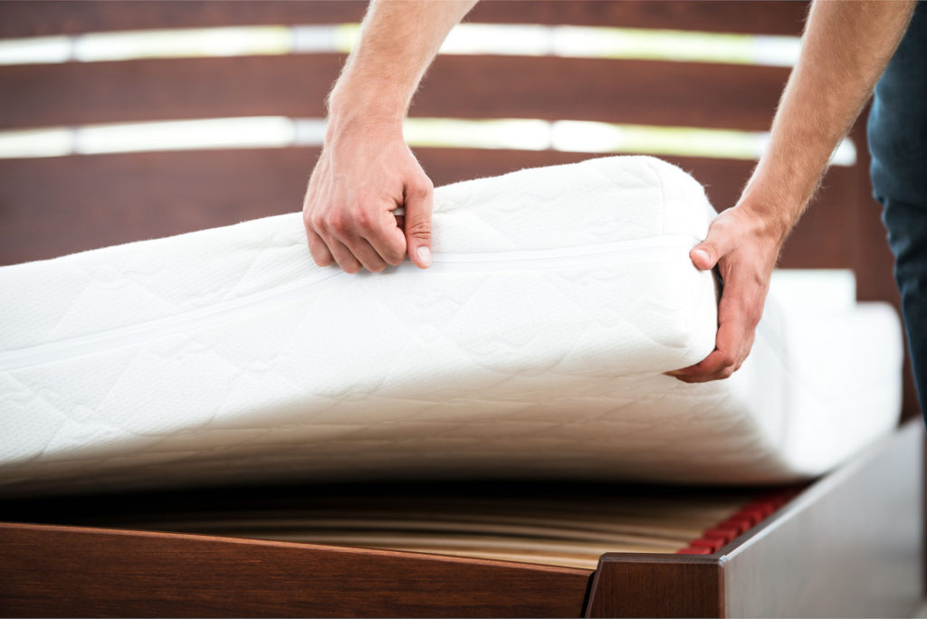 Person showing the thickness of a mattress