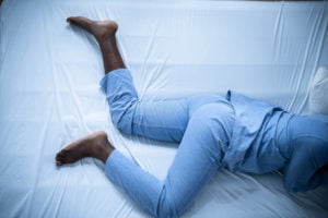 A person lying on a bed with Restless Legs