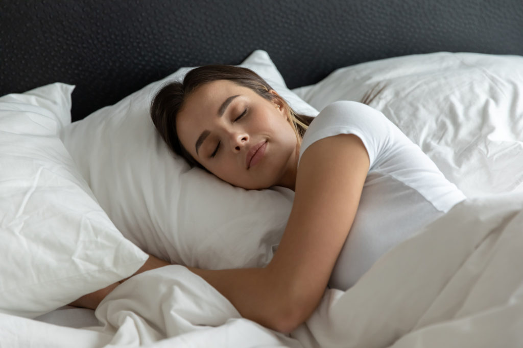 A woman is sleeping with several pillows