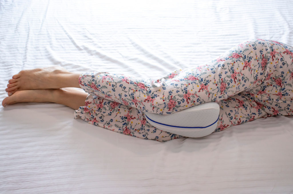 Person sleeping with a pillow between their knees