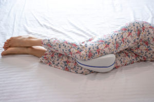 Person sleeping with a pillow between their knees