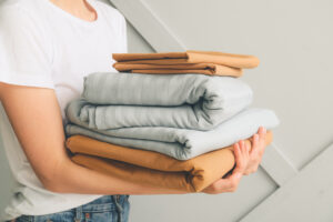 Woman with a stack of bedsheets