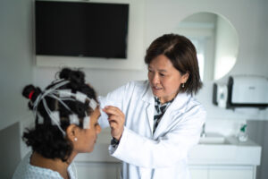 Doctor placing electrodes on patient's head for a polysomnography