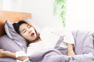 A woman sleeps with her mouth open