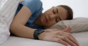 person wearing smart device to track oxygen levels during sleep
