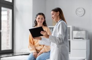A doctor uses a tablet to explain to a patient